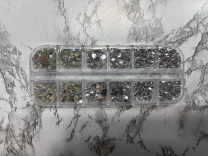 Container of rhinestones on a marble surface