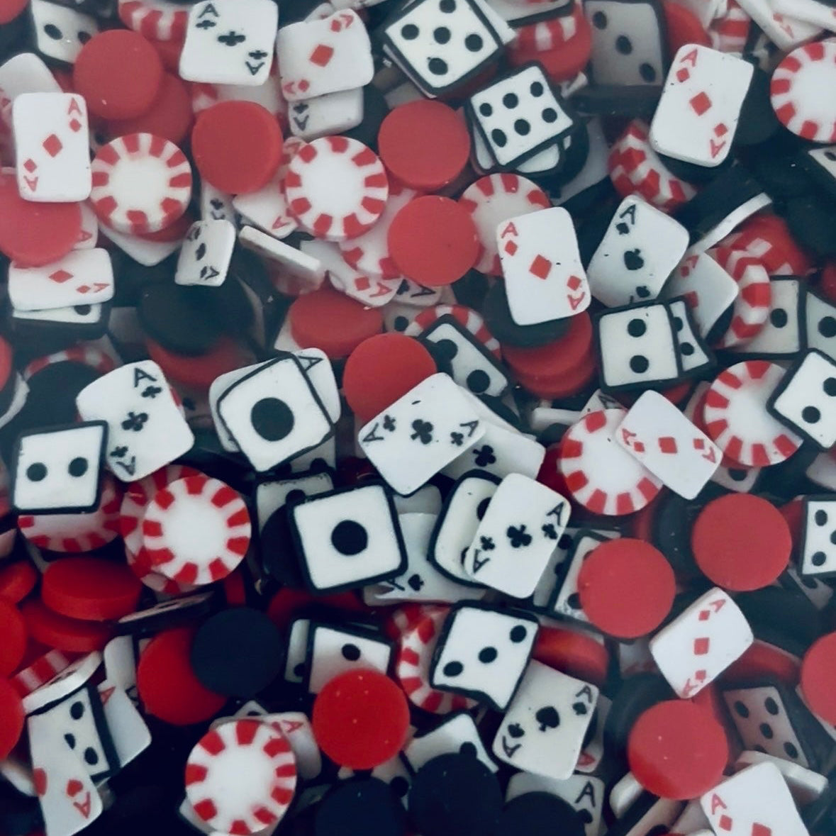 Assorted playing cards, poker chips, and dice in red, black, and white.