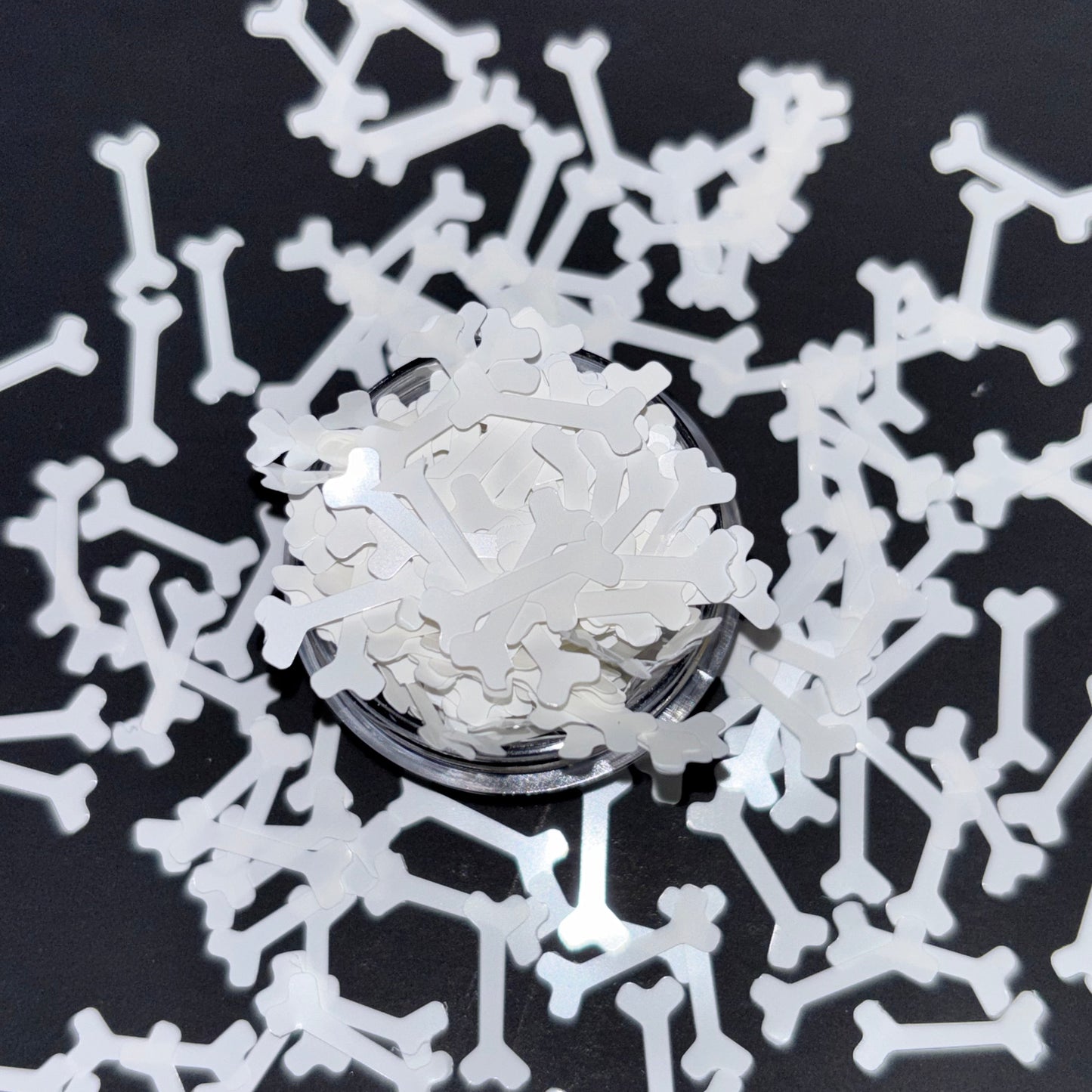 Close-up of a bone-shaped glitter with a black background