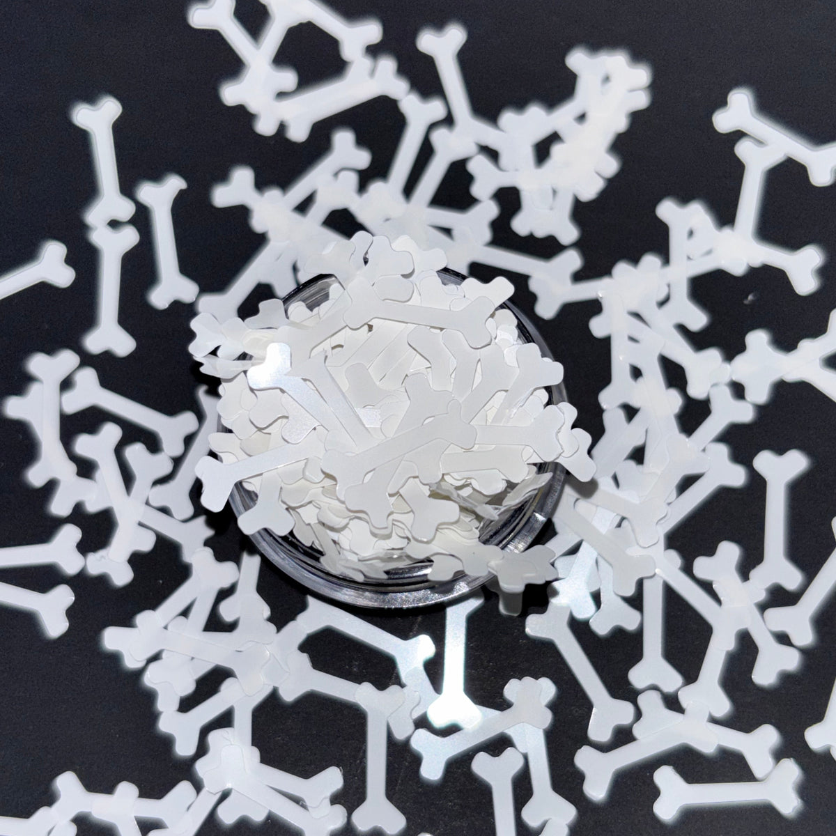 Close-up of a bone-shaped glitter with a black background