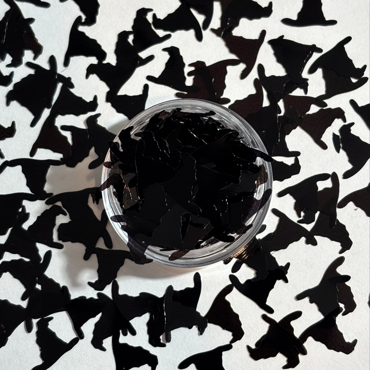 Black witch hat confetti on a white background