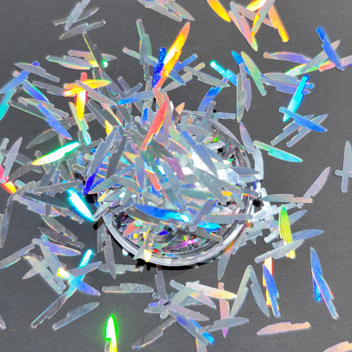 Multicolored iridescent confetti on a dark background