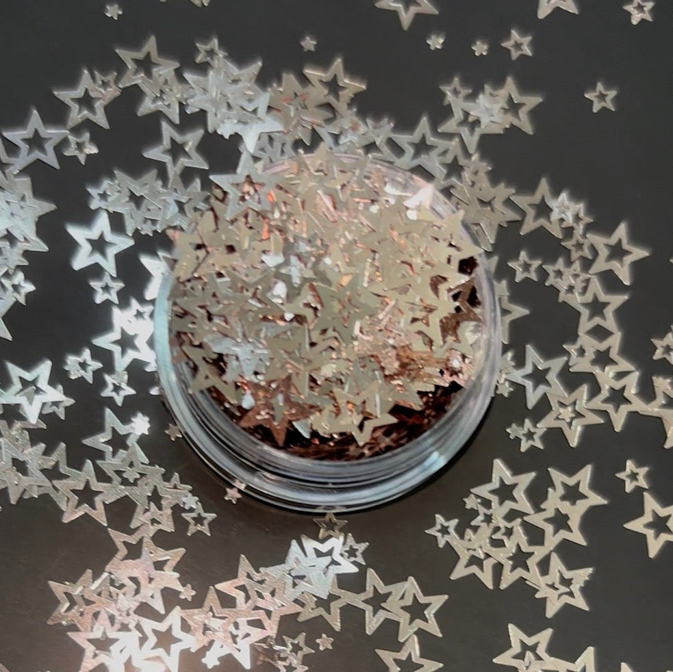 Star-shaped glitter in a clear container on a dark background with scattered star shapes.