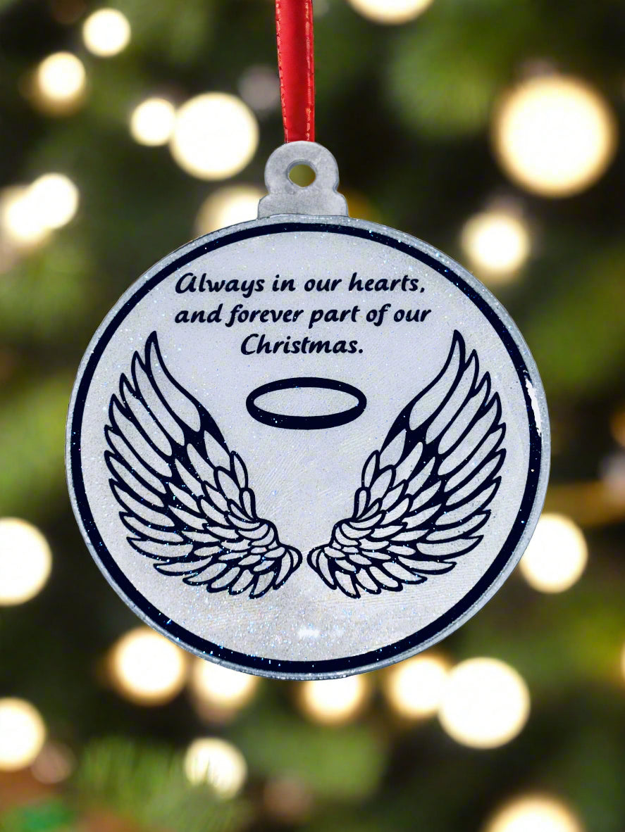 Circular pendant with wings and text on a concrete surface