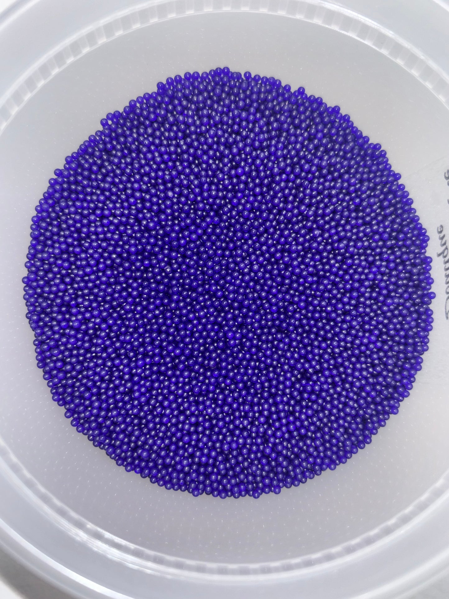Purple beads in a white container