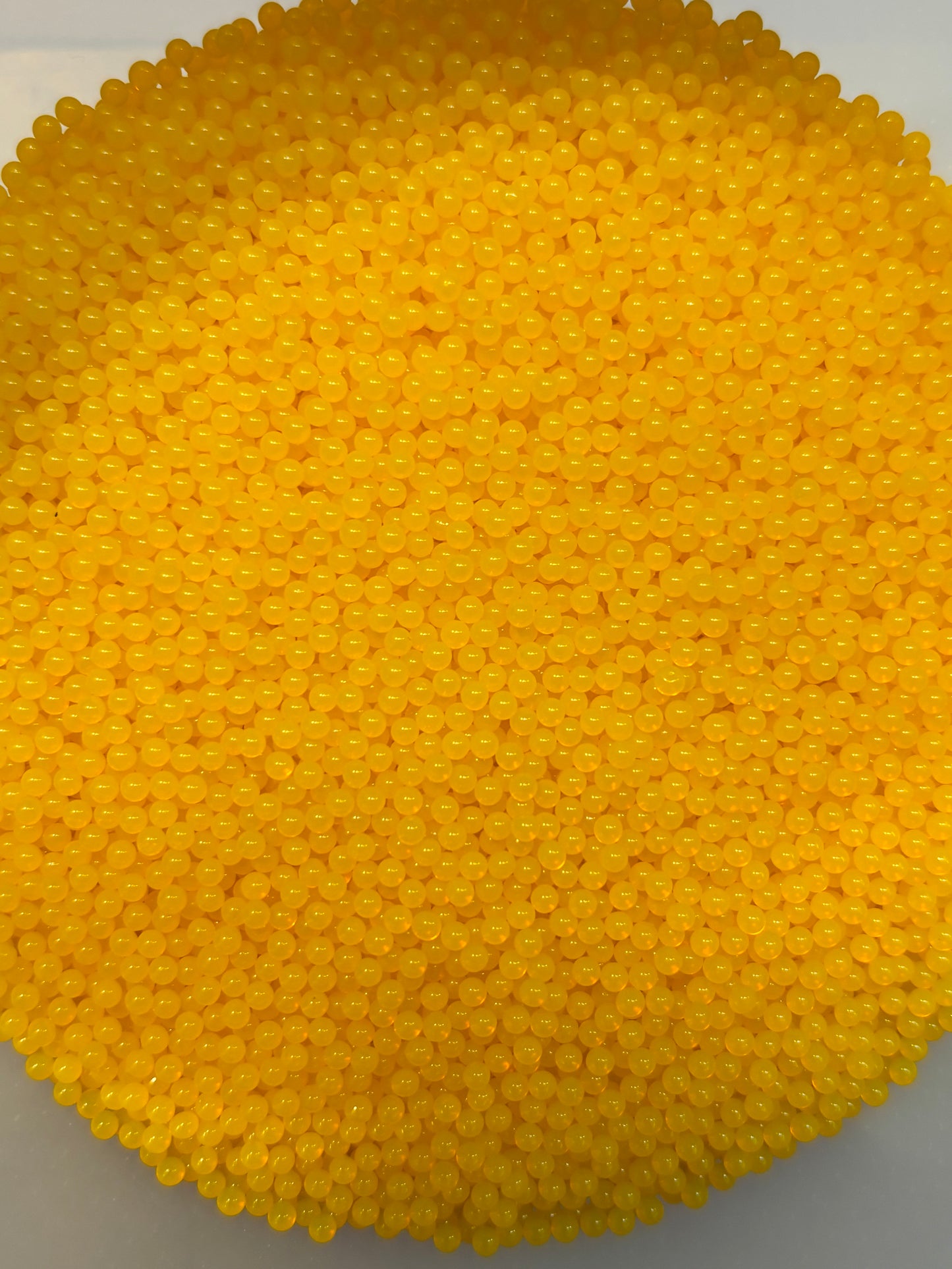 Close-up of a yellow beaded product on a gray background