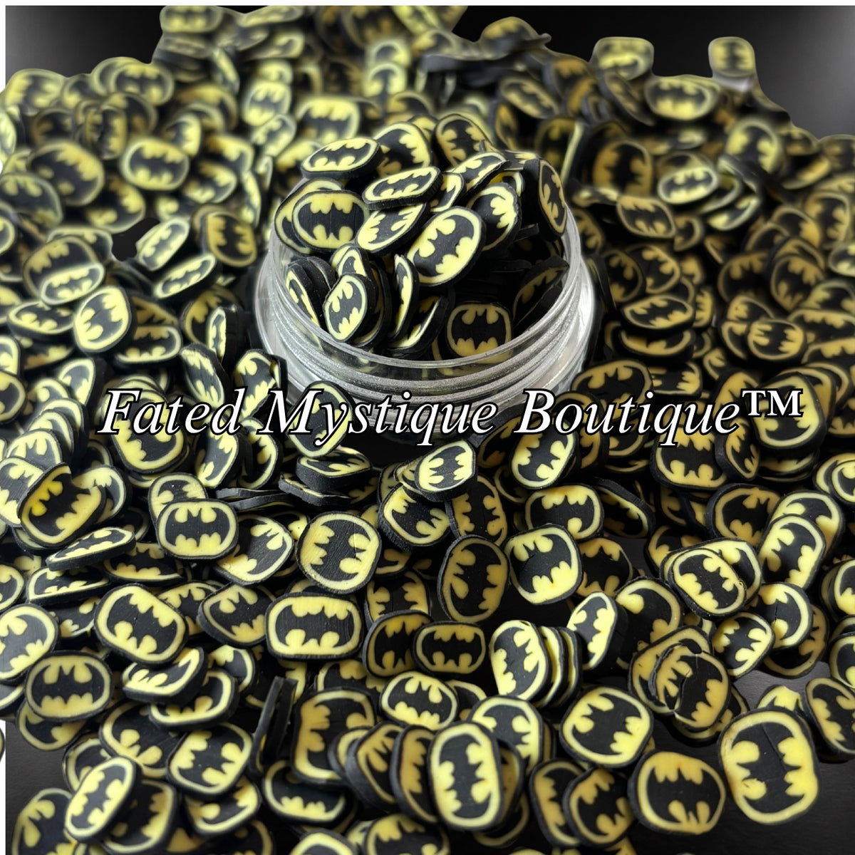 Batman black and yellow bat emblem polymer clay slices displayed in a clear jar with scattered slices