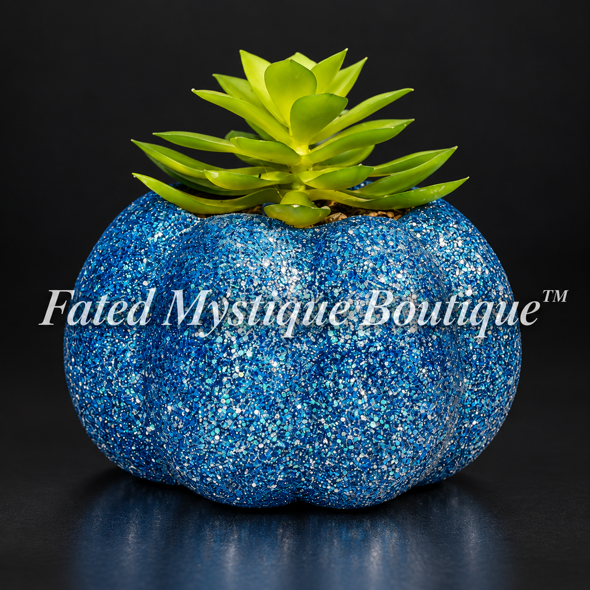 Dark blue glitter pumpkin planter with a green artificial succulent on a charcoal studio background.