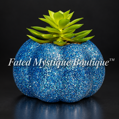 Dark blue glitter pumpkin planter with a green artificial succulent on a charcoal studio background.