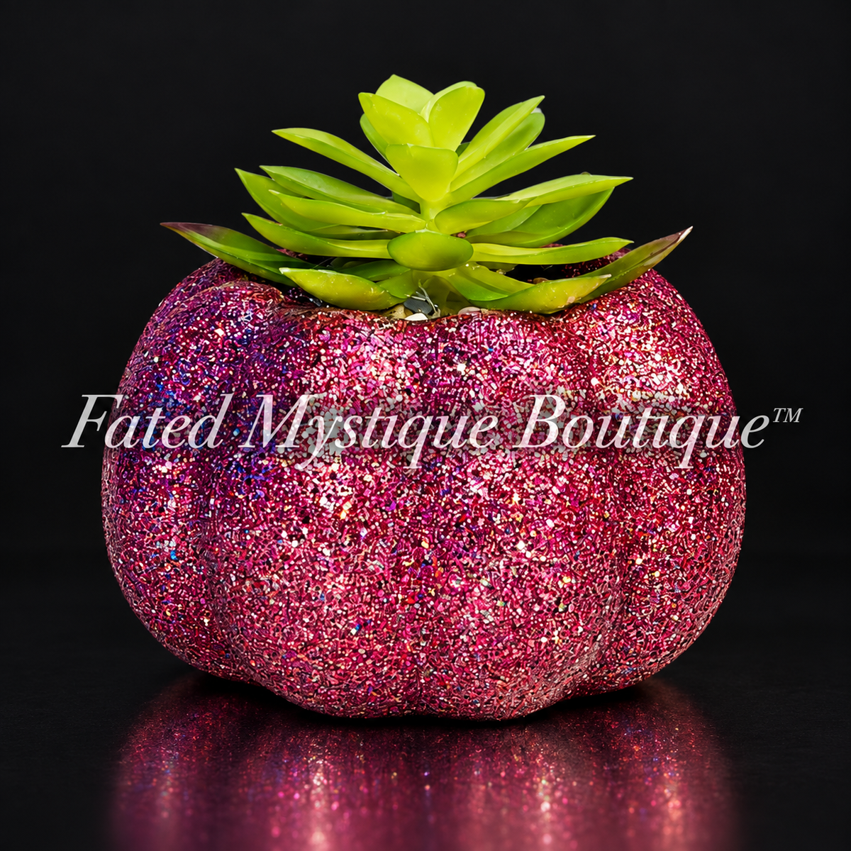 Dark pink glitter pumpkin planter with a green artificial succulent on a charcoal studio background.