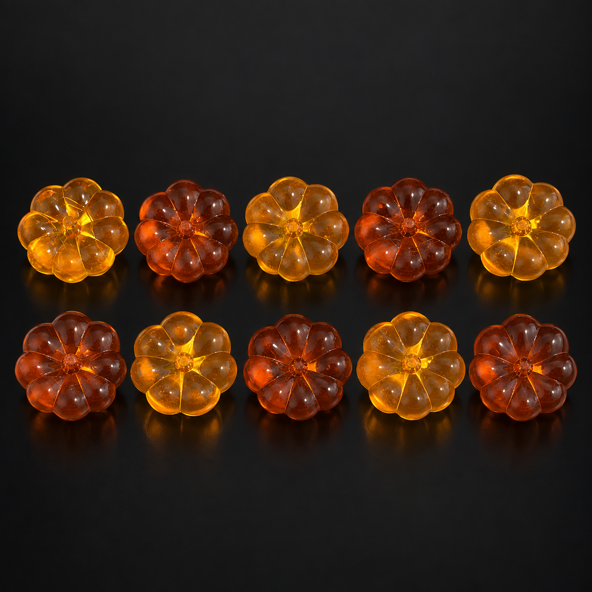 Random Fall-Colored Pumpkin Charms – 10 Pieces on a black studio background