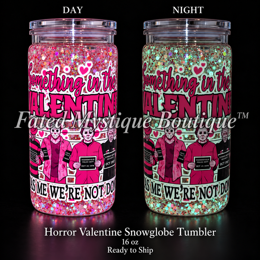 16 oz pink Horror Valentine snowglobe tumbler showing daytime glitter on the left and mint glow in the dark on the right