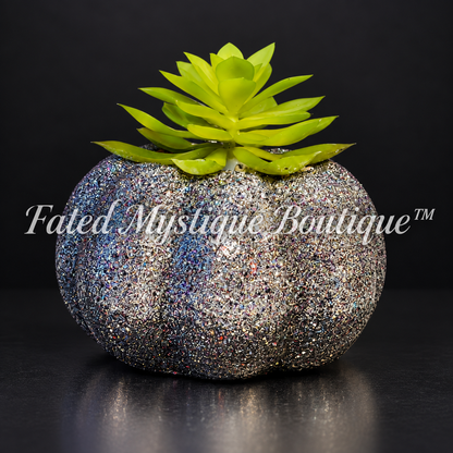 Silver and black glitter pumpkin planter with a green artificial succulent on a charcoal studio background.